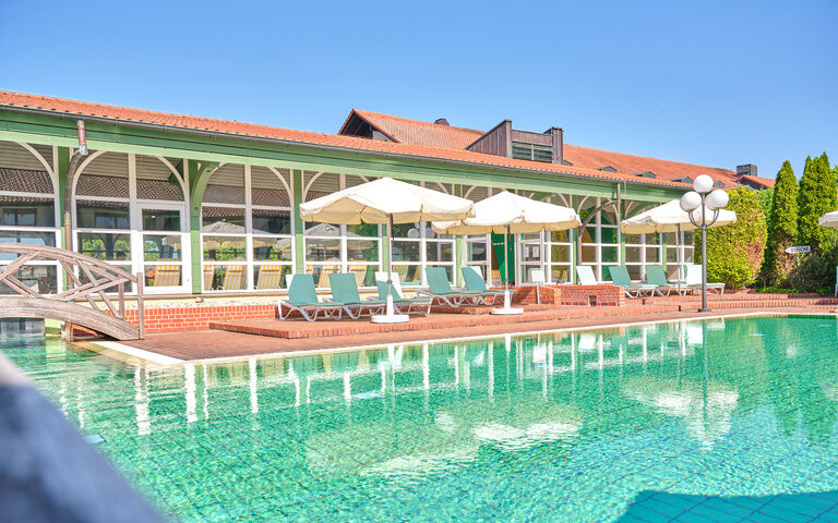 Poolansicht mit Liegen im Hintergrund bei sonnigem Wetter.